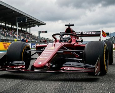 Monoplace de course moderne de 2026 sur une grille de départ, avec ses ailerons actifs visibles dans une ambiance de Grand Prix international.